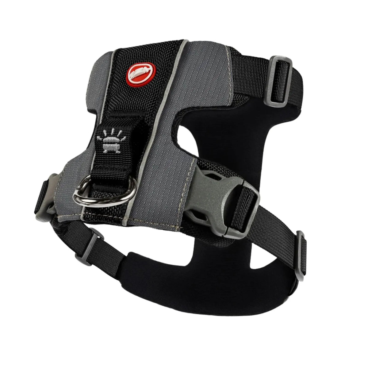 A gray and black dog harness with a red logo patch, metal D-ring, and plastic quick-release buckles, shown on a plain white background.