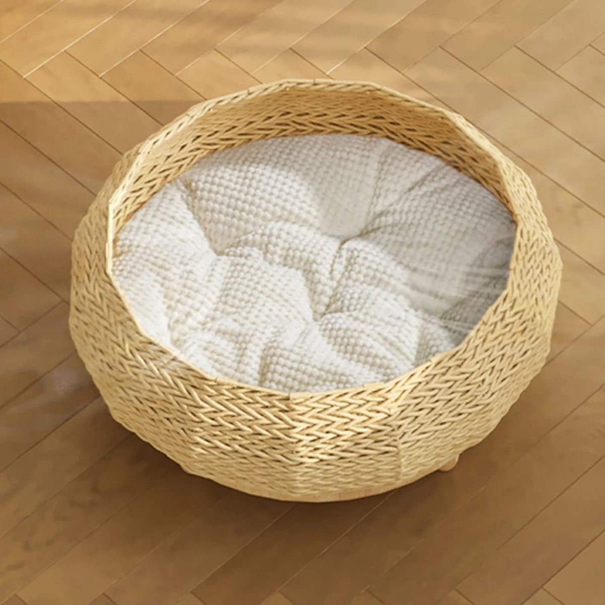 Scandi Meadow round woven cat nest bed with raised rubberwood feet and a soft cushion, on a light brown wooden floor.