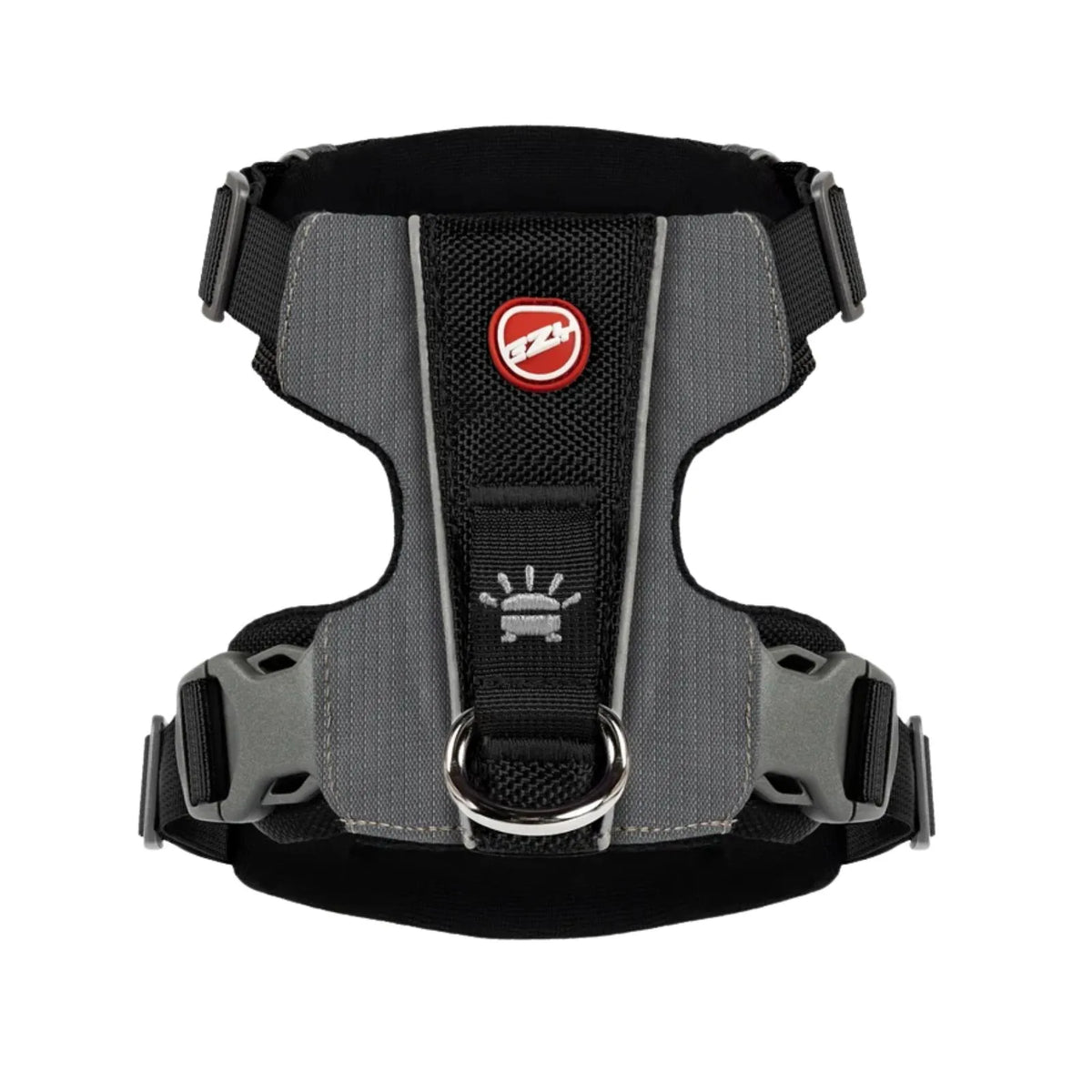 A black and gray dog harness with reflective gray stripes, a red circular logo patch, and a silver metal D-ring, shown against a plain white background.