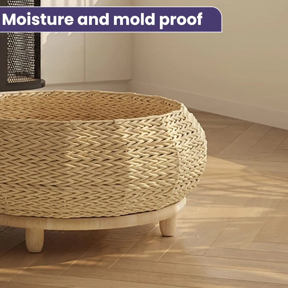 A round Scandi Meadow woven cat nest bed with raised light wood base and legs, shown in a real indoor room with wood flooring and a wall. A purple text banner at the top reads 'Moisture and mold proof'.