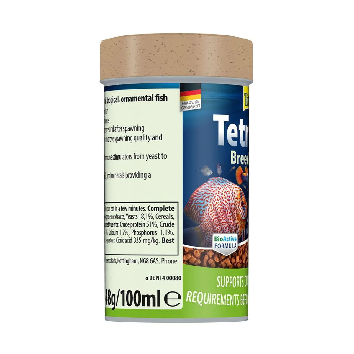 A cylindrical plastic jar of TetraBits Breeder food with a light brown textured lid, featuring a label with blue, green, and beige sections and an image of a red-and-white patterned fish.